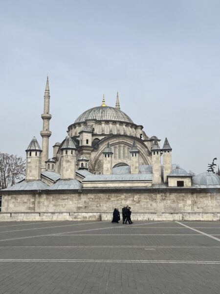 people walking in front of mosque