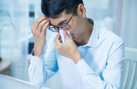 Man with cold blowing nose